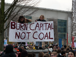 students holding sign "burn capital not coal" 