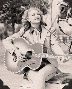 Cindy Walker playing Gene Autry's guitar Vintage image of Cindy Walker playing Gene Autry's guitar