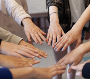 girls hands held towards each other in a circle, like spokes on a wheel