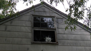 A photo of an attic window with the Self Help Radio logo in it.